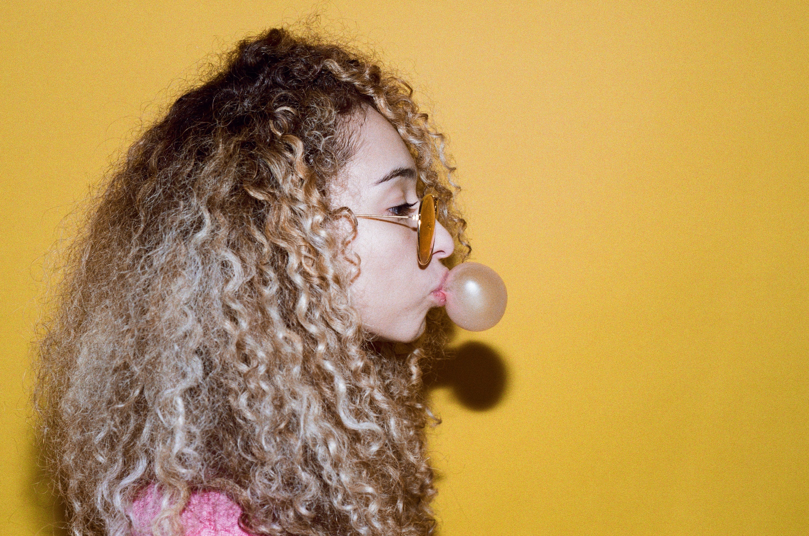 picture of girl with sunglasses with dyed dry curly hair