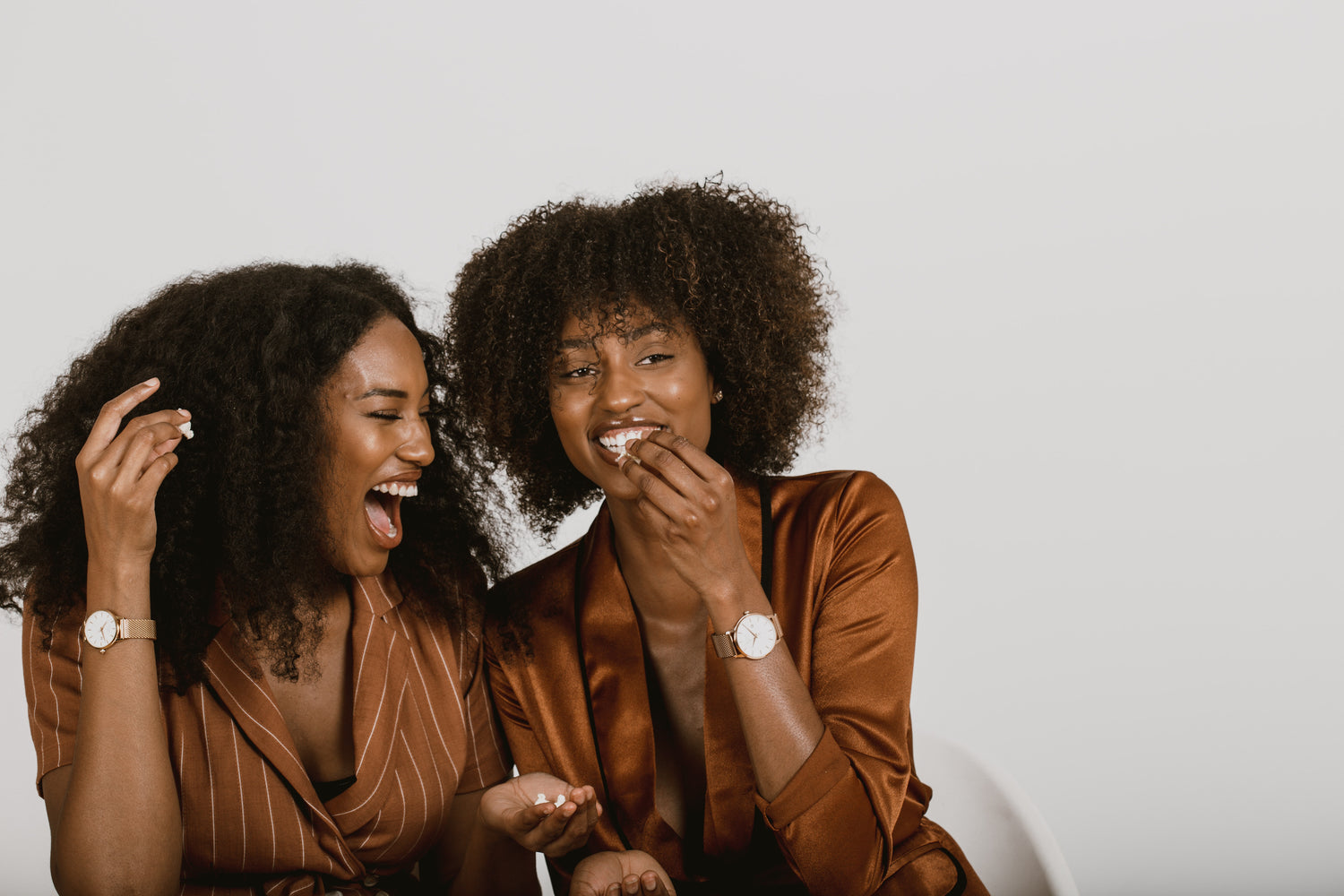 two women talking about what causes curly hair