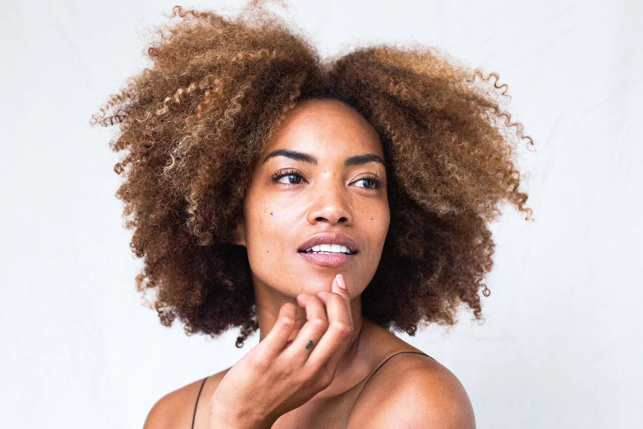 Curly hair woman thinking about how to stop hair shrinkage